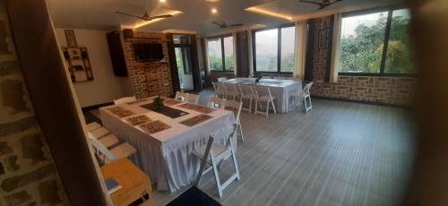 a room with two tables and chairs and windows at Experto The Greens in Nainital