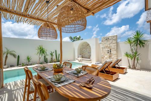 een terras met een tafel en stoelen en een zwembad bij 7Seas Bingin in Uluwatu