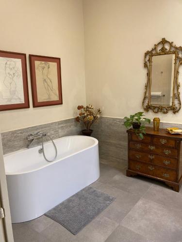 a white bath tub in a bathroom with a mirror at Palatial Flat inside Bright Duplex Penthouse in Valletta