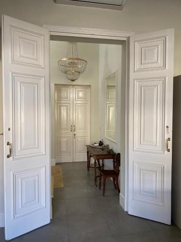 a hallway with a table and a chandelier at Palatial Flat inside Bright Duplex Penthouse in Valletta