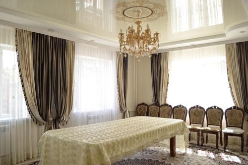 a dining room with a table and chairs and a chandelier at Zara in Bishkek