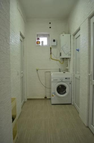 a laundry room with a washing machine and a window at Zara in Bishkek
