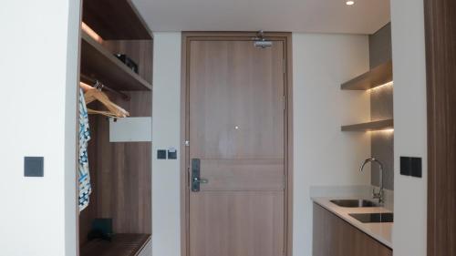a wooden door in a kitchen with a sink at Apec Boutique Hotel Phú Yên in Tuy Hoa