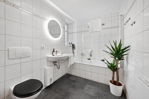 a white bathroom with a toilet and a sink at Apartments am Hainich - 6 Personen, King-Size-Betten, Netflix, Nationalpark in Hörselberg-Hainich