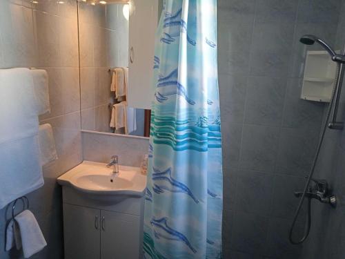 a bathroom with a shower curtain with a sink at Apartments Ana Lopud - One Bedroom Apartment with Balcony and Sea View - 3 1 floor in Lopud Island