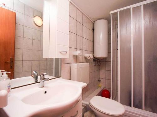a bathroom with a sink and a toilet at Apartments Ere Zuronja-One-Bedroom Apartment with Sea View 2 in Putniković