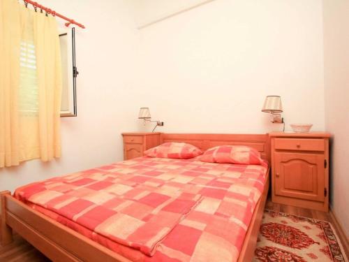 a bedroom with a bed with a checkered blanket at Apartments Ere Zuronja-One-Bedroom Apartment with Sea View 2 in Putniković