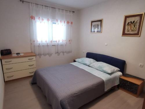 ein Schlafzimmer mit einem Bett, einer Kommode und einem Fenster in der Unterkunft Apartment Nera ST - Two-Bedroom Apartment with Sea View in Omiš