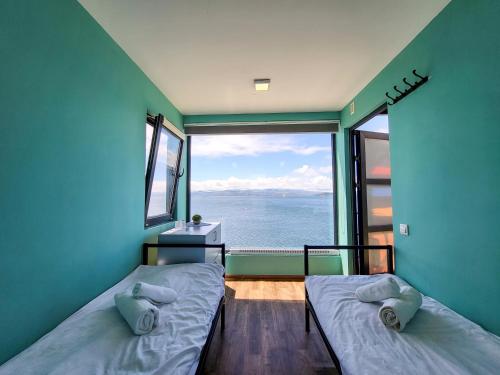 two beds in a room with a view of the ocean at Altitude 1900 Dive Resort, Lake Sevan in Chambarak