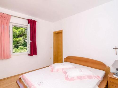 a white bedroom with a bed and a window at Apartments Villa Bella Vista - Two Bedroom Apartment with Balcony and Sea View in Potomje