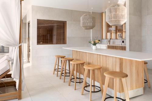 a kitchen with wooden stools at a counter at Clarion Hotel Karlatornet in Gothenburg