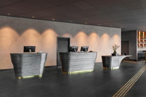 a lobby with three desks with computers on them at Clarion Hotel Karlatornet in Gothenburg