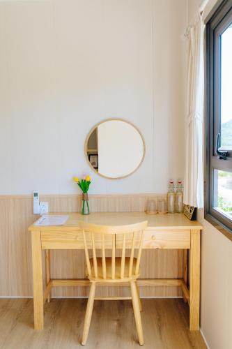 a wooden desk with a chair and a mirror at Antus Homestay in Quang Ninh