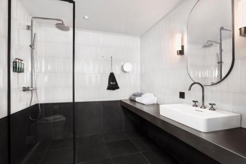 a bathroom with a sink and a shower at Clarion Hotel Karlatornet in Gothenburg