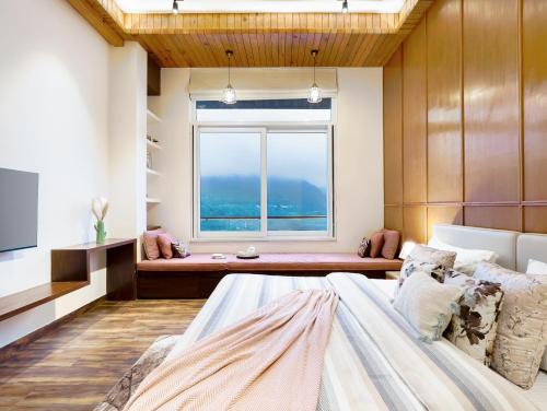 a bedroom with a large bed and a window at ELIVAAS 4 BHK with Balcony & Terrace - Antarmann Casa Nova in Bhīm Tāl