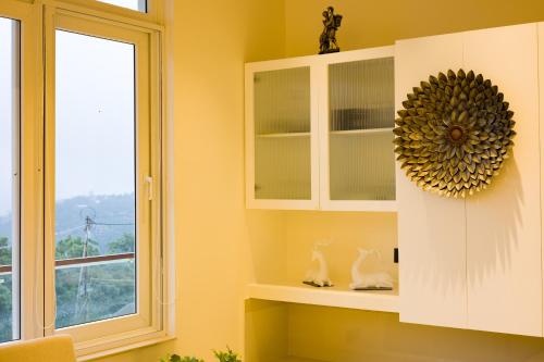 a kitchen with a white cabinet and a window at ELIVAAS 4 BHK with Balcony & Terrace - Antarmann Casa Nova in Bhīm Tāl