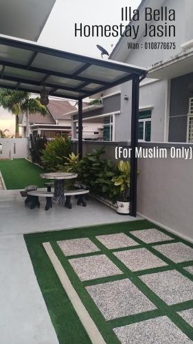 a patio with two benches and a table in front of a house at illa Bella Homestay Jasin in Jasin