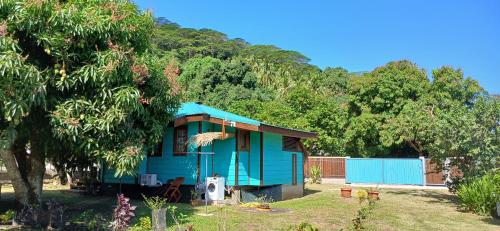 a blue tiny house in the middle of a yard at Faré tropical atiha in Tuarea