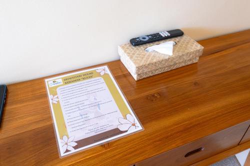 a table with a remote control and a box on it at Sriwedari House Keramas in Gianyar