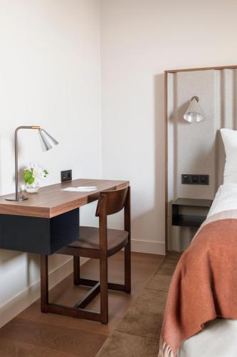 a desk with a lamp and a chair next to a bed at Clarion Hotel Karlatornet in Gothenburg
