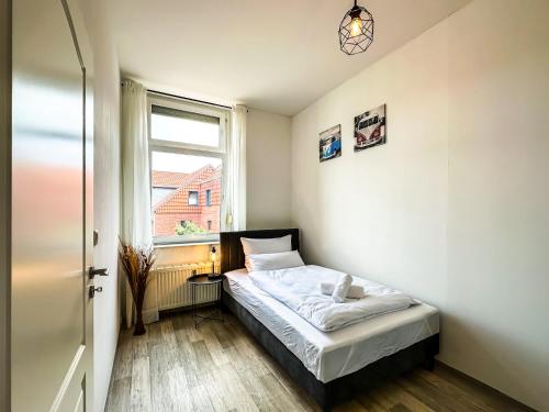 ヴォルフスブルクにあるR und S Apartments Stylische Wohnung I Küche I Parkplatz I Smart TVのベッドと窓のある小さな寝室