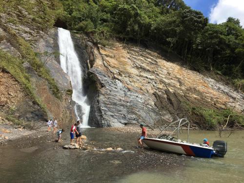 a group of people standing in the water next to a boat at Tres Marias Chivor in Batá