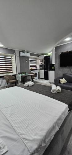 Una cama blanca grande en una habitación con cocina. en LUX-Апартаменты New York style на Чехова, en Öskemen