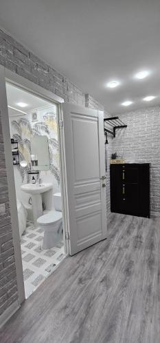 baño con aseo y puerta blanca en LUX-Апартаменты New York style на Чехова, en Öskemen