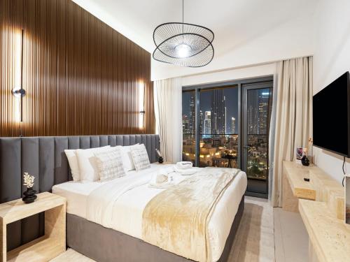 a bedroom with a large bed and a large window at SmartStay at Burj Royale - Full Burj Khalifa View - Brand New Luxury Apartments in Dubai
