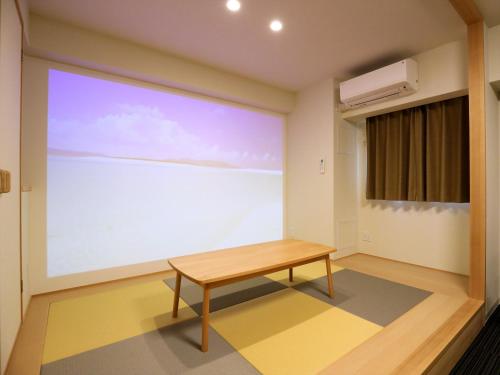 a room with a large projection screen with a bench at MERBABU STAY OSAKA in Osaka