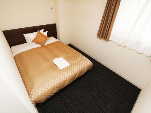 a small bed in a room with a window at MERBABU STAY OSAKA in Osaka