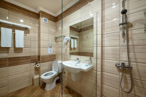 a bathroom with a toilet and a sink and a shower at Hotel Riva Park - All Inclusive in Sunny Beach