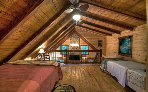Zimmer im Dachgeschoss mit 2 Betten und einem Deckenventilator in der Unterkunft Knotty Creek Retreat - Creek Access, Outdoor Firepit + Hot Tub with Creek Views! in Morganton