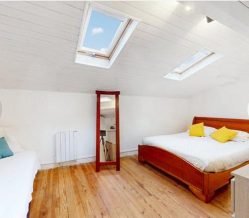 a bedroom with a bed with yellow pillows and a window at Maison typique royannaise dans un quartier calme in Royan