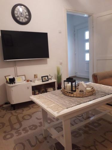 un soggiorno con tavolo e TV a schermo piatto di Apartman Tanja Trebinje a Hrupjela