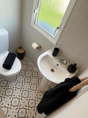 a bathroom with a sink and a toilet at 75 Lakeside East Haggerston Castle Park in Cheswick