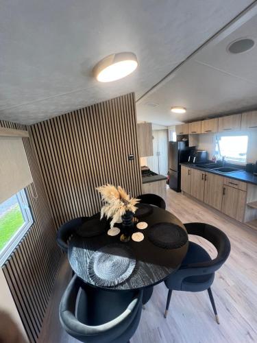 a table and chairs in a room with a kitchen at 75 Lakeside East Haggerston Castle Park in Cheswick