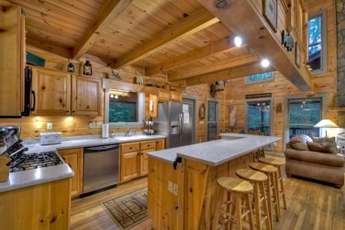 a kitchen with a large center island in a log cabin at K6 Lodge Gather around the firepit soak in the hot tub and splash in the creek in Blue Ridge