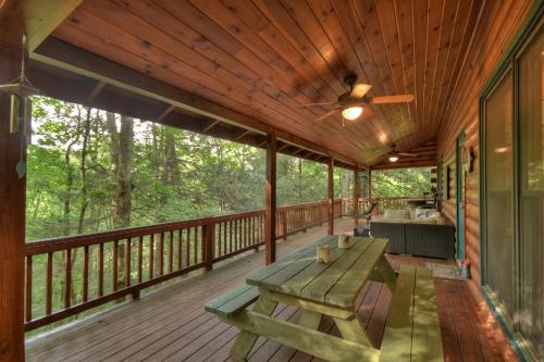 a screened porch with a picnic table and a ceiling fan at K6 Lodge Gather around the firepit soak in the hot tub and splash in the creek in Blue Ridge