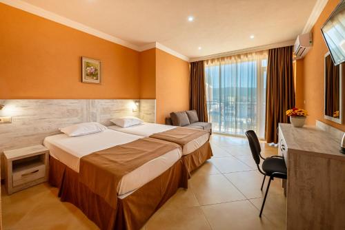 a hotel room with a large bed and a desk at Hotel Riva Park - All Inclusive in Sunny Beach