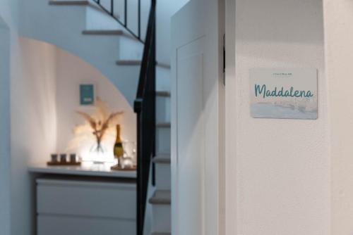 a door with a sign on it next to a staircase at A Casa di Elena in Polignano a Mare