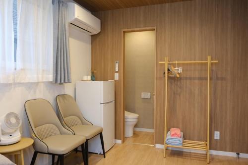 a small room with two chairs and a refrigerator at 楽Home in Otaru