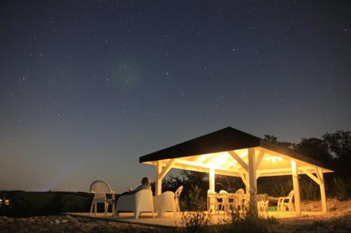 a man sitting under a gazebo at night at Siedlisko Panorama na Koncu Swiata - Całoroczny domek in Podgórz