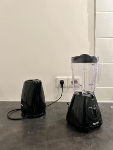 Deux mélangeurs noirs sont assis au-dessus d'un comptoir dans l'établissement Studio équipé, gare à 3km entre Versailles et SQY, à Guyancourt