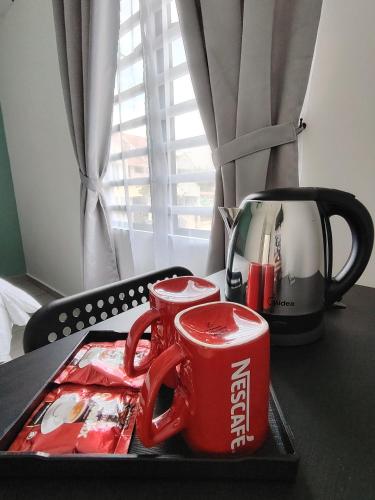 a tray with two coke mugs on a table at Austin Melaka in Kampong Sungai Putat