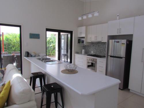 a kitchen with white cabinets and a white counter top at Casuarina Escape by Kingscliff Accommodation in Casuarina