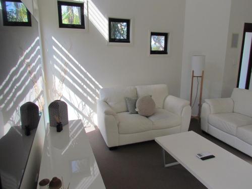 a living room with a white couch and a table at Casuarina Escape by Kingscliff Accommodation in Casuarina