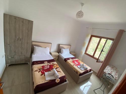 a bedroom with two beds and a window at Villa Romario in Berat