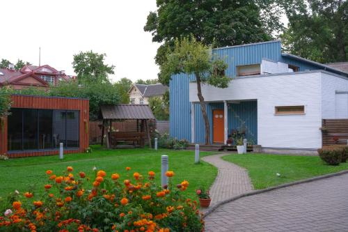 a house with a garden with orange flowers in the yard at Villa Meri in Pärnu