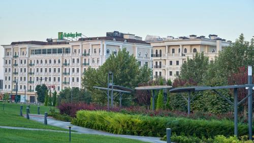 a park in front of a large building at Holiday Inn Tashkent City by IHG in Tashkent